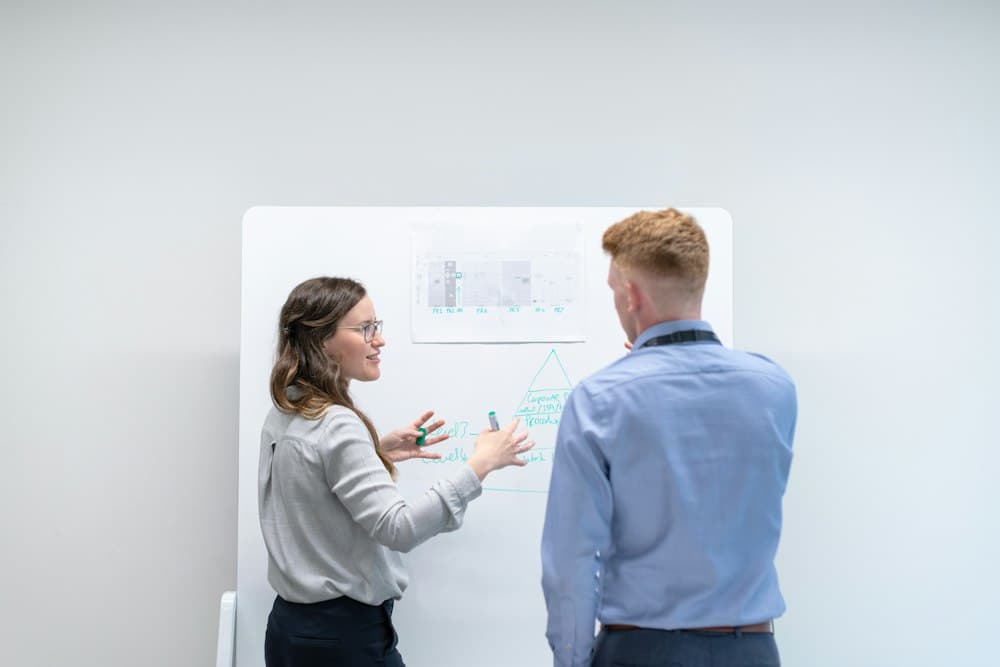 Two colleagues mapping ideas on a whiteboard